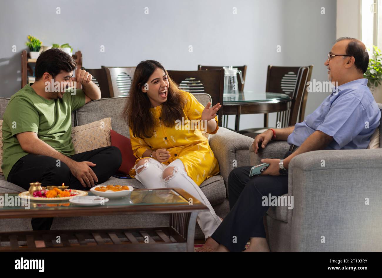 Felice famiglia indiana seduta a casa e parlando tra di loro su Raksha Bandhan Foto Stock