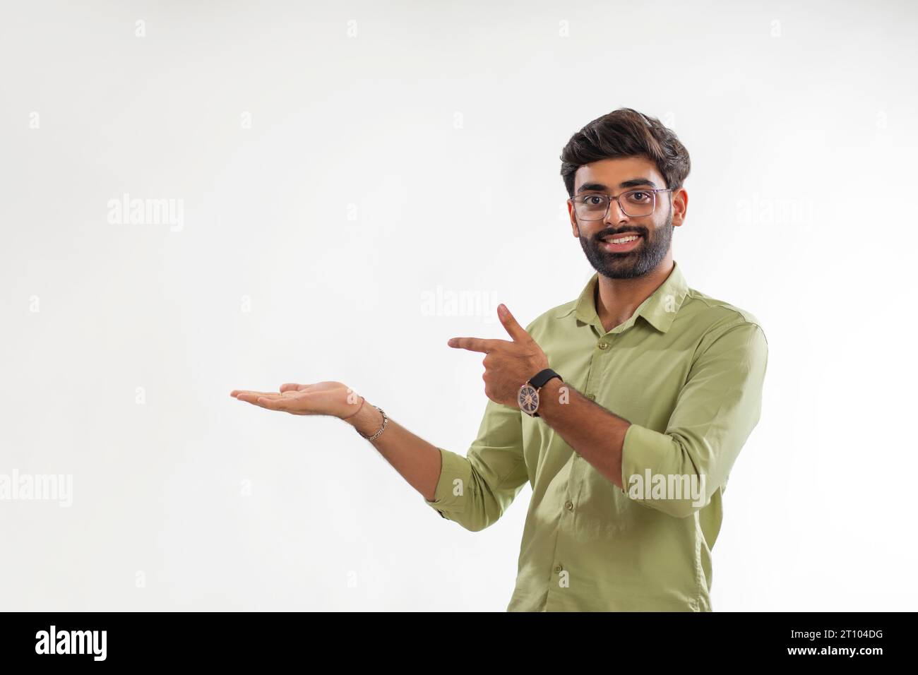 Ritratto di un giovane che punta alla sua palma vuota su sfondo bianco Foto Stock