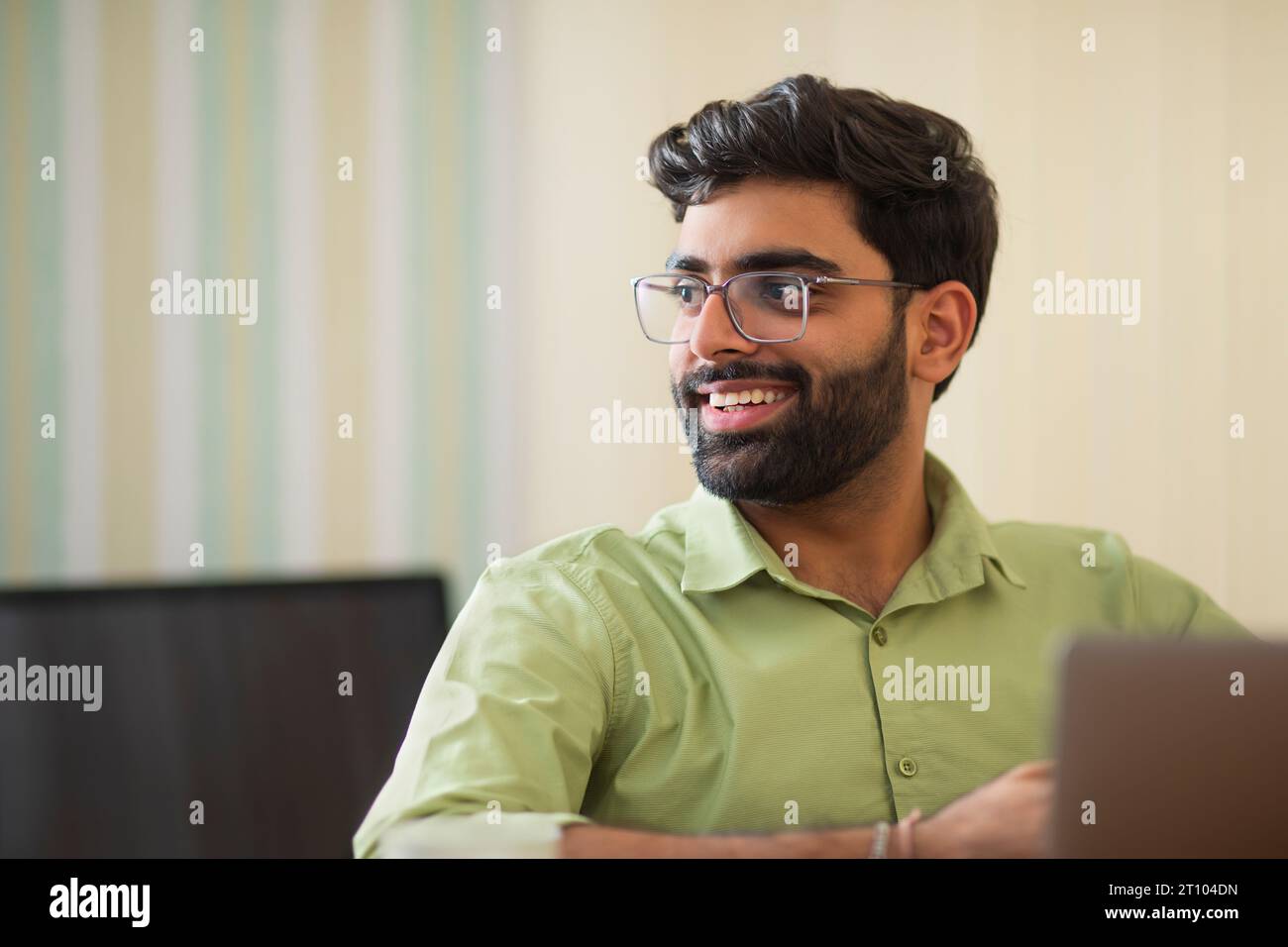 Ritratto ravvicinato di un giovane che lavora con un notebook nel suo ufficio domestico Foto Stock