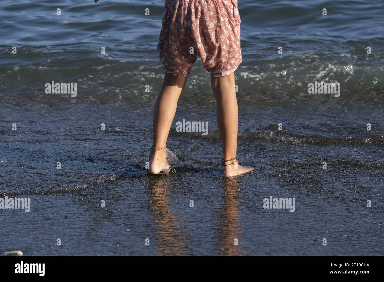 ragazza che salta sulla riva giocando tranquillamente in autunno Foto Stock