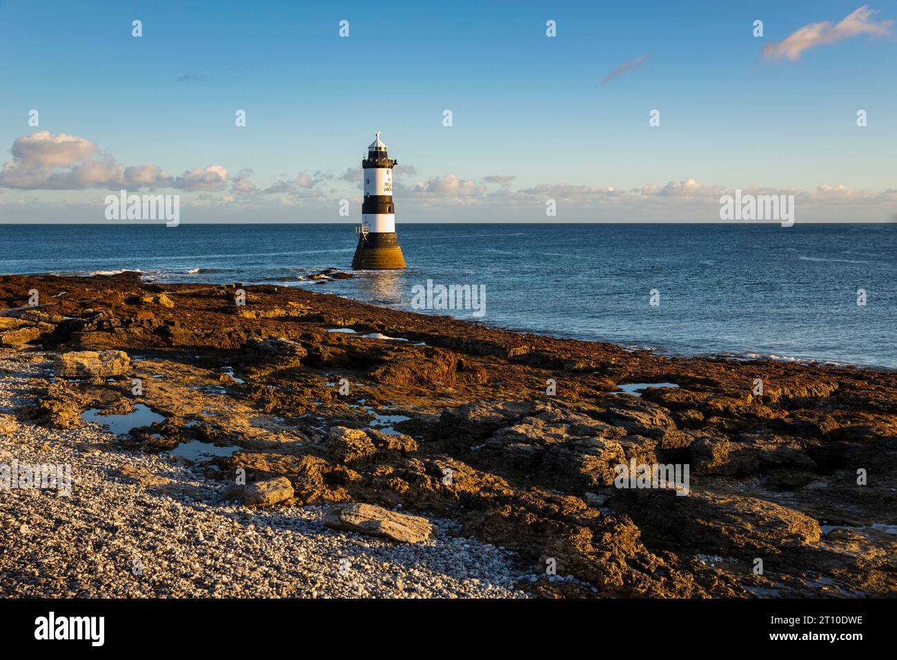 Penmon Point sulla costa di Anglesey, Galles del Nord. Il famoso faro di Trwyn Du alla luce del sole del mattino. Foto Stock