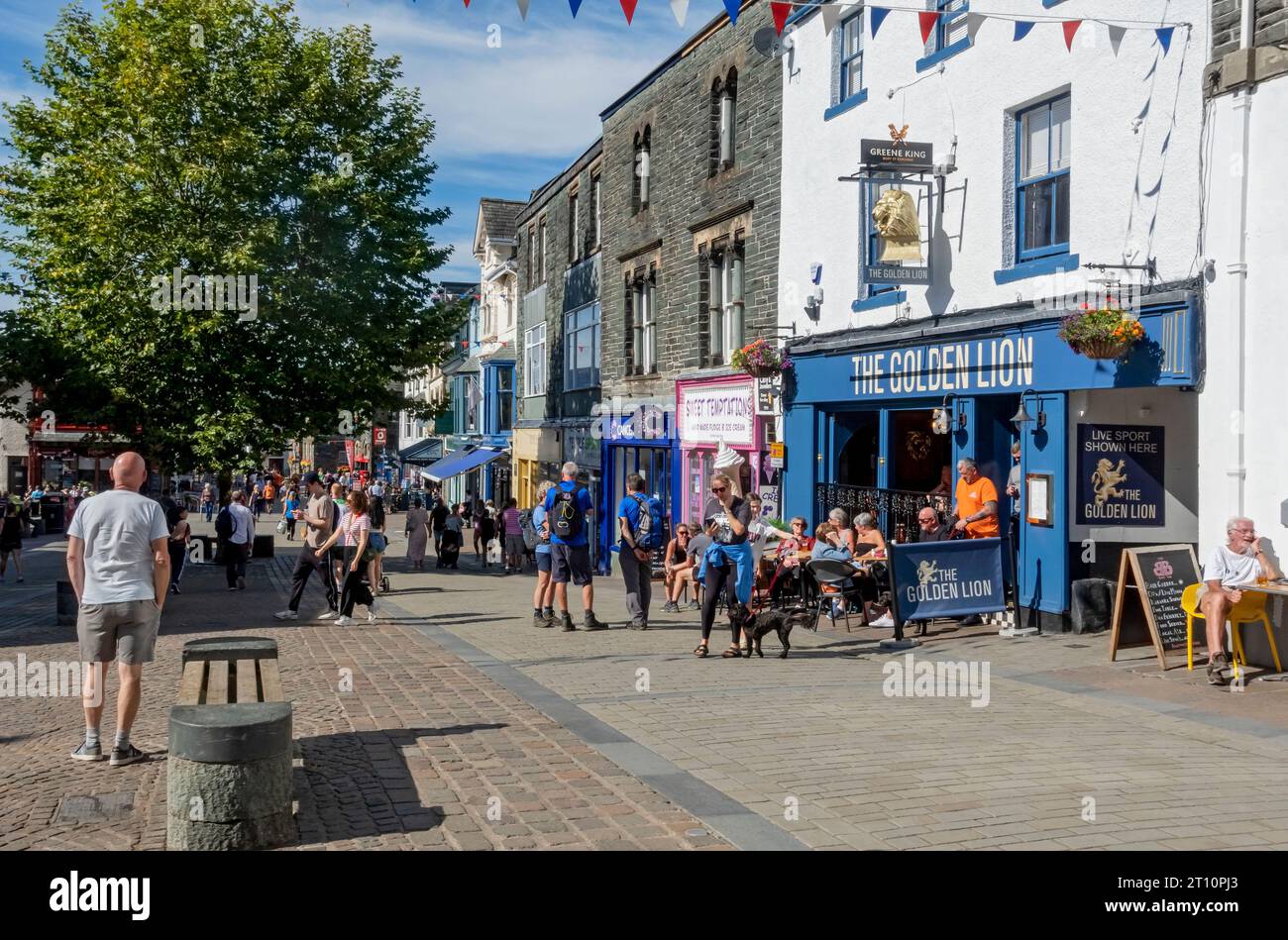 Persone turisti visitatori e negozi nella strada del centro città in estate Main Street Keswick Lake District Cumbria Inghilterra Regno Unito Gran Bretagna Foto Stock