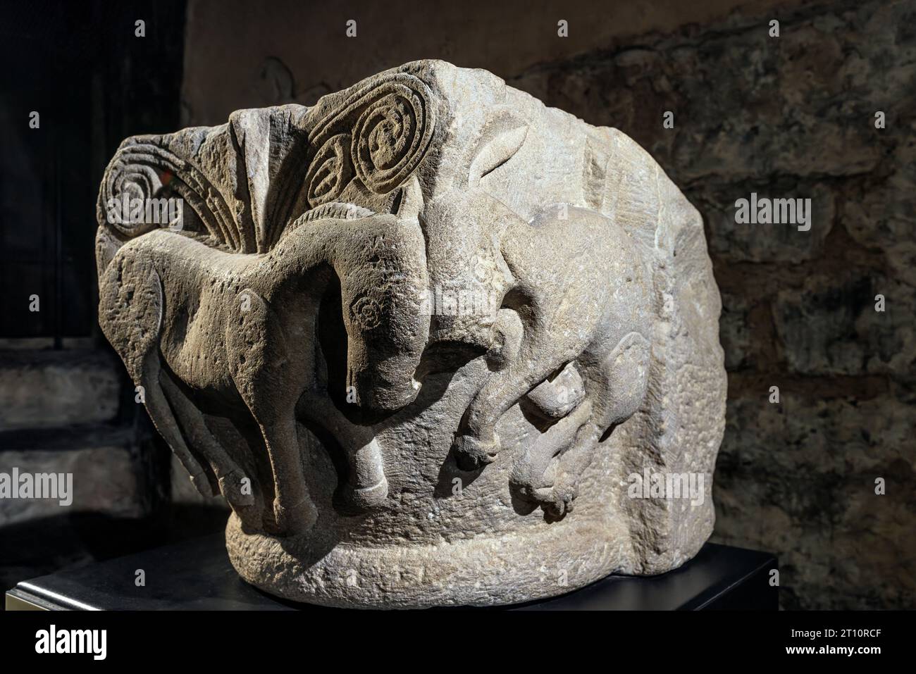 Capitale pre-romanica di una colonna con un cavallo di passaggio e lepri accovacciate nella cripta sotto la cattedrale di Ventimiglia in Liguria. Foto Stock