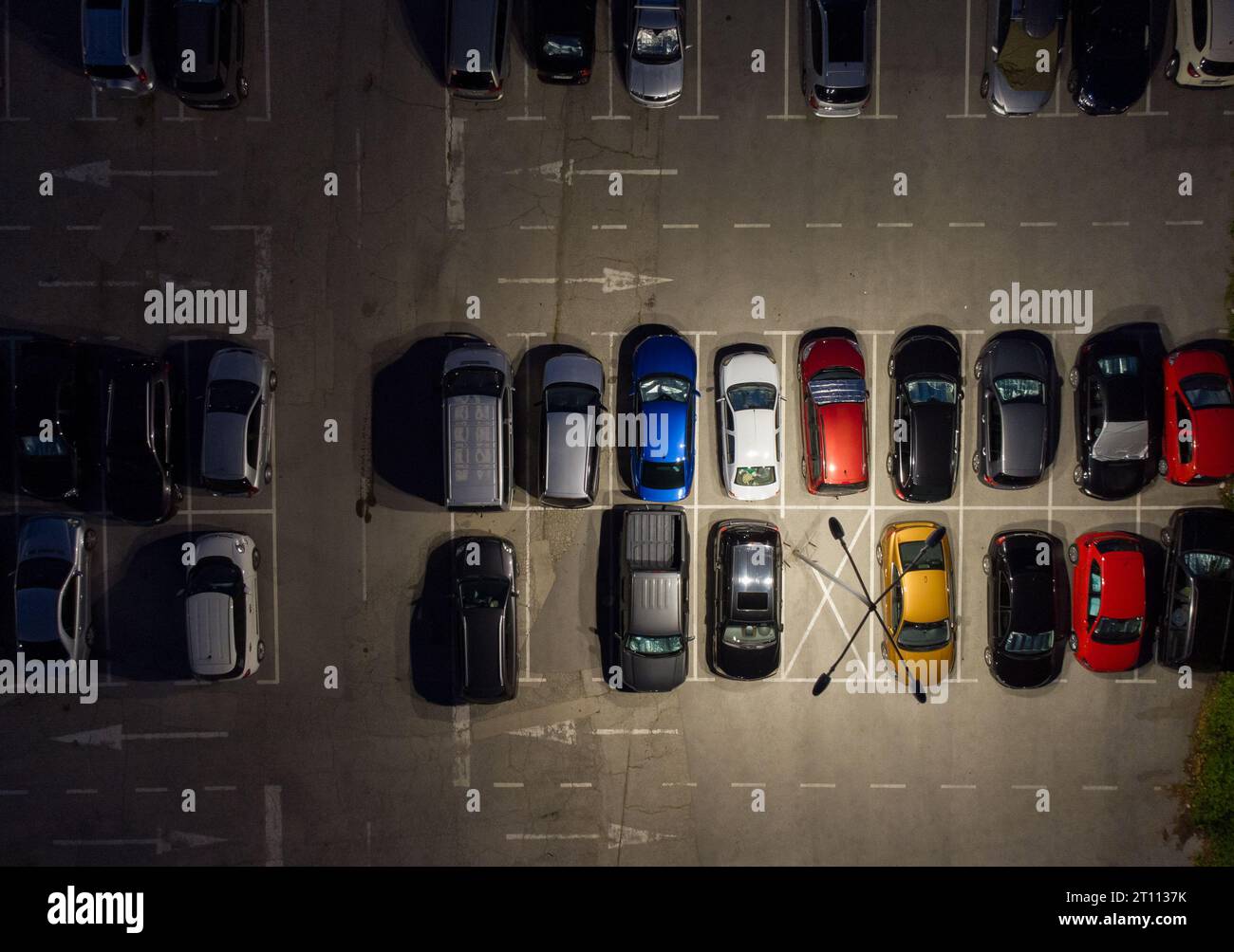 Vista aerea dall'alto dei parcheggi con auto di notte. Foto Stock