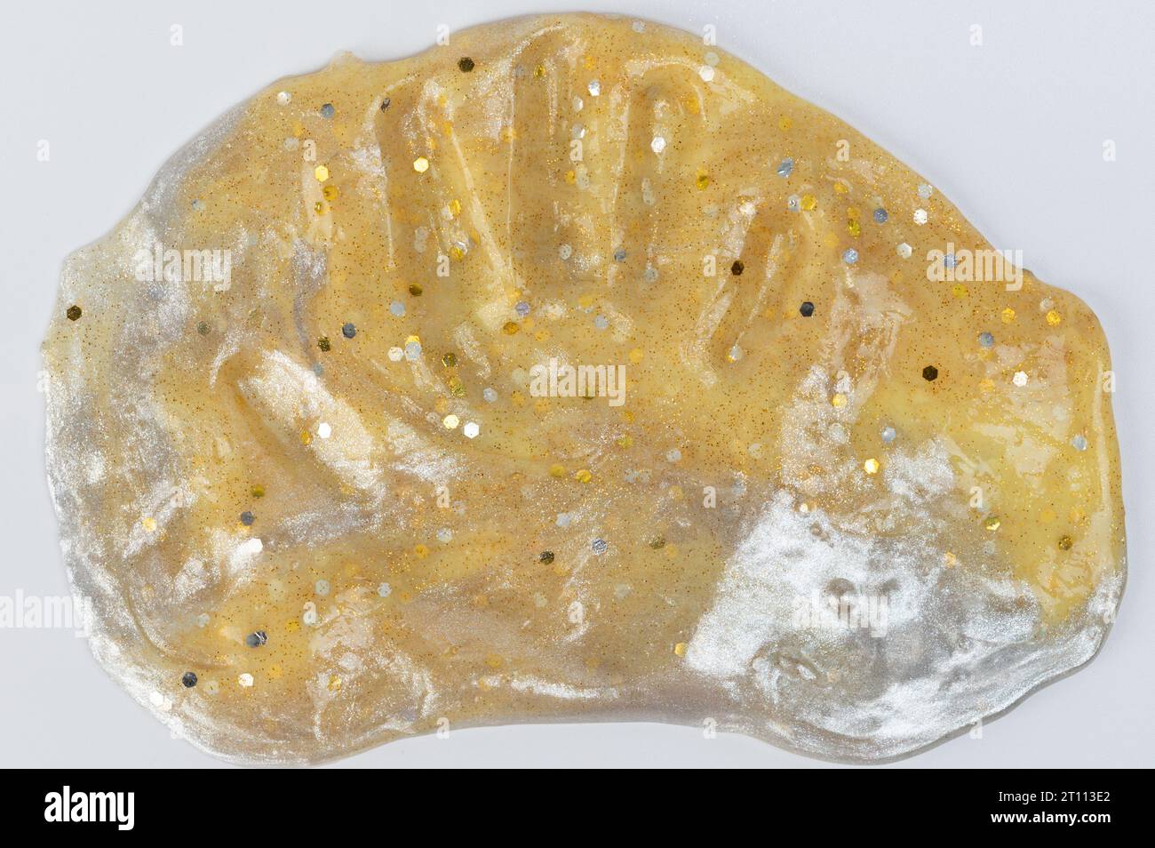Traccia di palme umane su un servizio di melma di colore dorato isolato su sfondo bianco dello studio Foto Stock