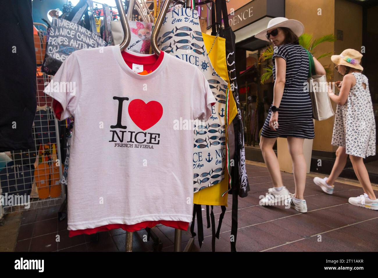 T-shirt/T-shirt "i Love Nice" appesa su un espositore su marciapiede, con logo a forma di cuore, in vendita in un negozio di souvenir turistico a Nizza, Francia. (135) Foto Stock