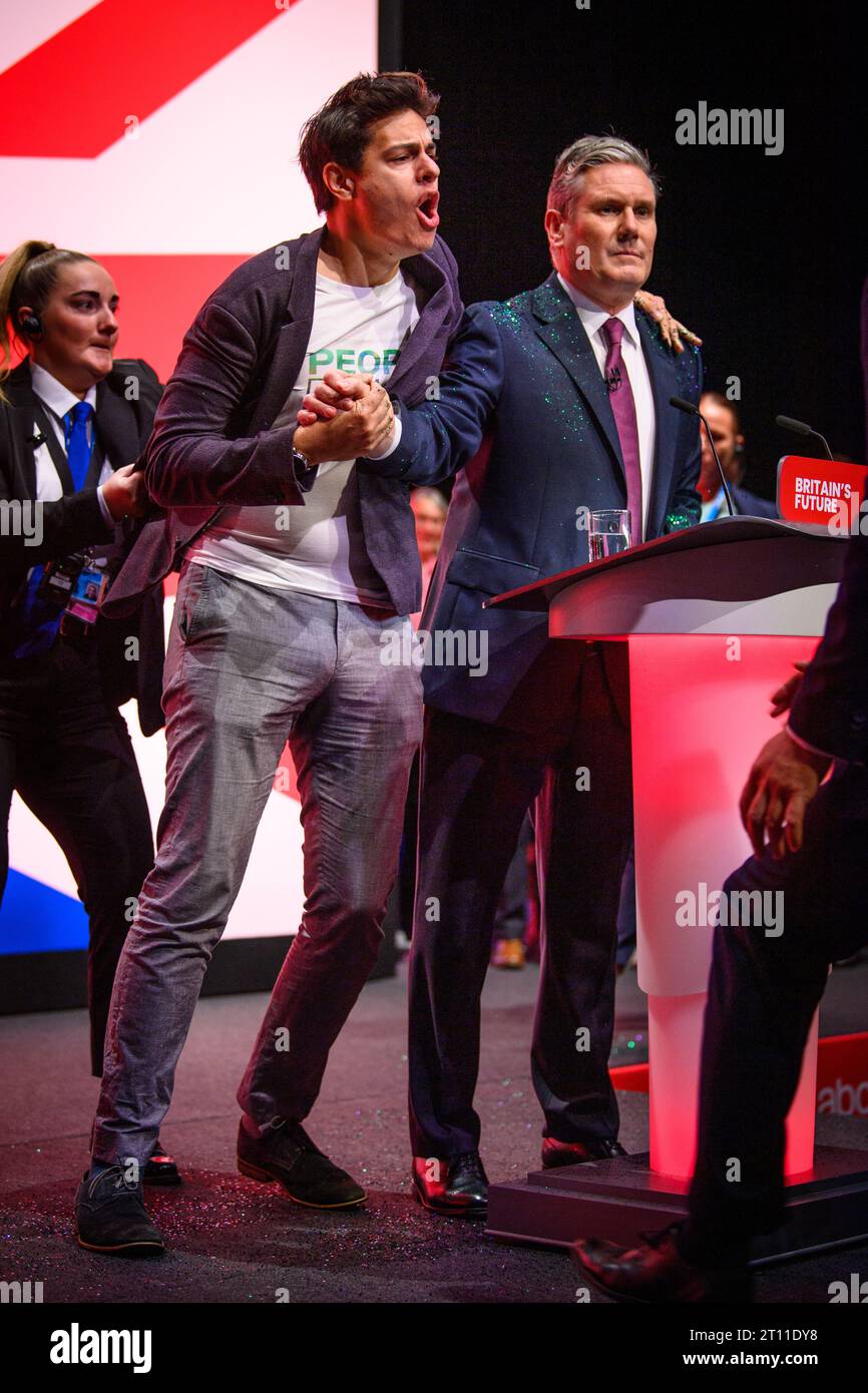 Londra, Regno Unito. 10 ottobre 2023. Un manifestante lancia brillantini sul leader del Partito Laburista Keir Starmer prima del suo discorso, durante la Conferenza del Partito Laburista a Liverpool. Il credito fotografico dovrebbe essere: Matt Crossick/Empics/Alamy Live News Foto Stock