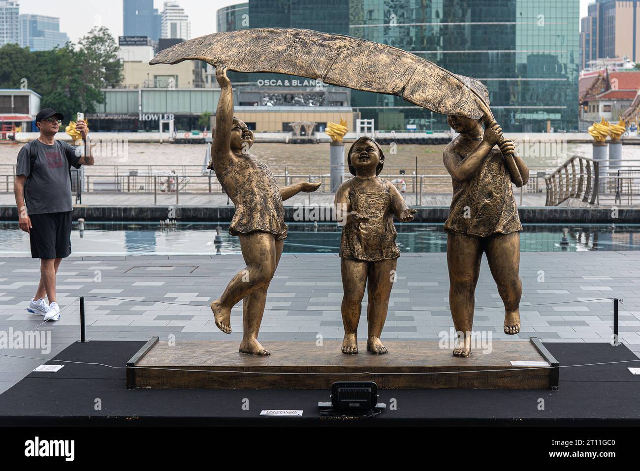 Un visitatore scatta una foto di una scultura creata dall'artista cinese Xu Hongfei fuori dal centro commerciale Iconsiam. Una mostra 'Xu Hongfei Sculpture World Tour Exhibition - Thailand: Love in Siam' si è tenuta a Iconsiam, il centro commerciale con sculture create dall'artista cinese Xu Hongfei che presentano felicità, umorismo e relazione tra Thailandia e Cina. Foto Stock