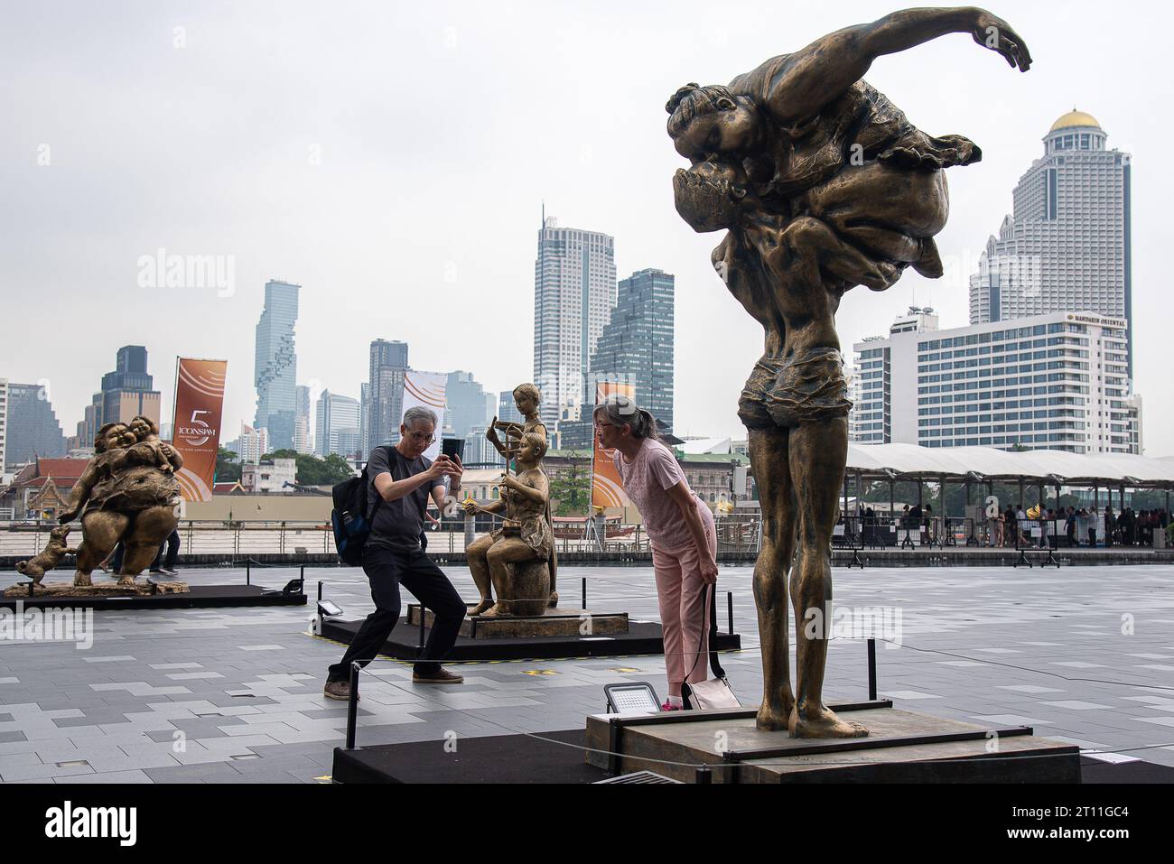 I visitatori scattano foto accanto a una scultura creata dall'artista cinese Xu Hongfei fuori dal centro commerciale Iconsiam. Una mostra 'Xu Hongfei Sculpture World Tour Exhibition - Thailand: Love in Siam' si è tenuta a Iconsiam, il centro commerciale con sculture create dall'artista cinese Xu Hongfei che presentano felicità, umorismo e relazione tra Thailandia e Cina. Foto Stock