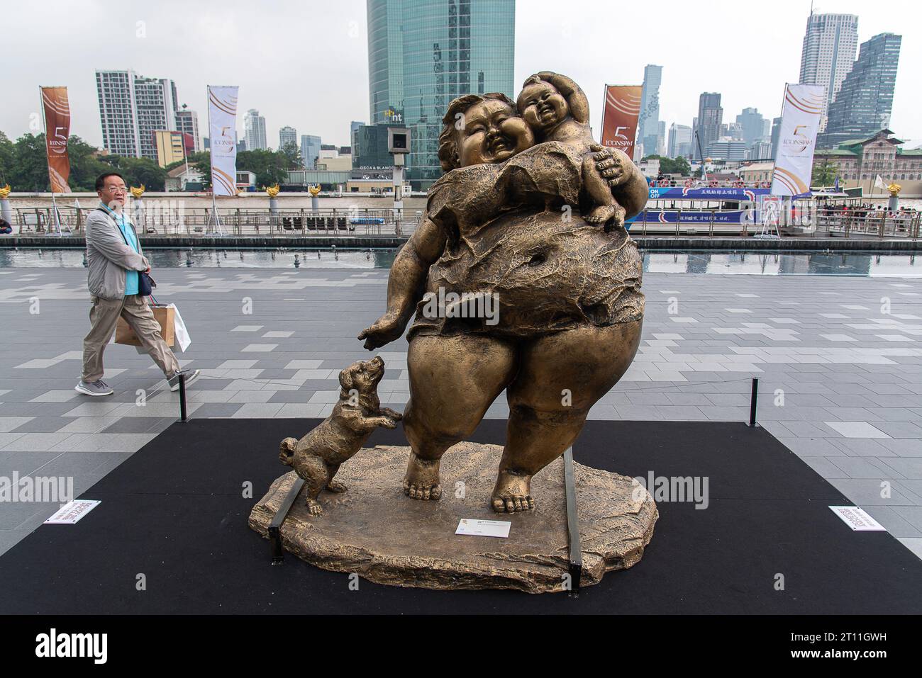 Bangkok, Thailandia. 10 ottobre 2023. Un visitatore guarda una scultura creata dall'artista cinese Xu Hongfei fuori dal centro commerciale Iconsiam. Una mostra 'Xu Hongfei Sculpture World Tour Exhibition - Thailand: Love in Siam' si è tenuta a Iconsiam, il centro commerciale con sculture create dall'artista cinese Xu Hongfei che presentano felicità, umorismo e relazione tra Thailandia e Cina. (Foto di Peerapon Boonyakiat/SOPA Images/Sipa USA) credito: SIPA USA/Alamy Live News Foto Stock