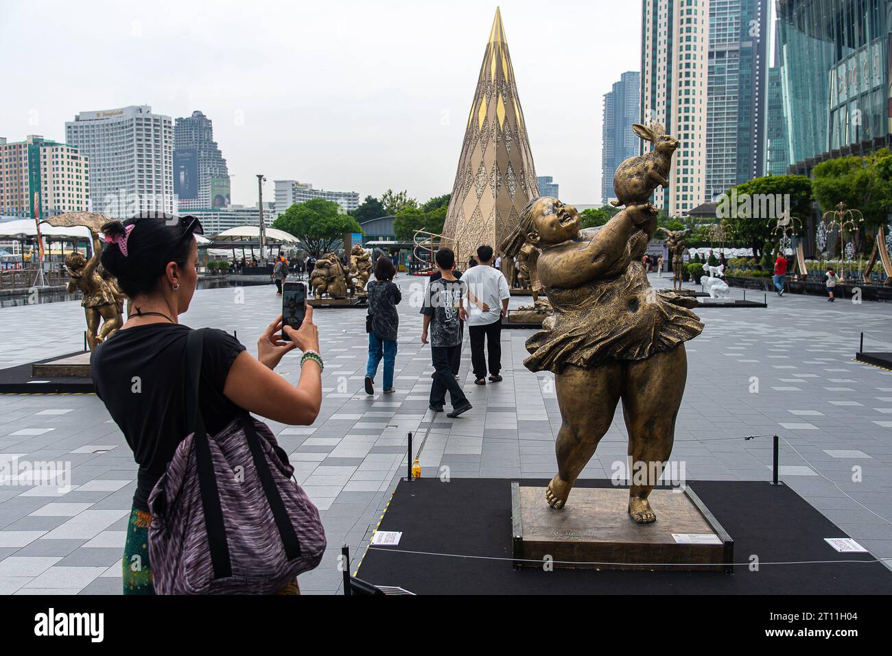 Bangkok, Thailandia. 10 ottobre 2023. Un visitatore scatta una foto di una scultura creata dall'artista cinese Xu Hongfei fuori dal centro commerciale Iconsiam. Una mostra 'Xu Hongfei Sculpture World Tour Exhibition - Thailand: Love in Siam' si è tenuta a Iconsiam, il centro commerciale con sculture create dall'artista cinese Xu Hongfei che presentano felicità, umorismo e relazione tra Thailandia e Cina. (Foto di Peerapon Boonyakiat/SOPA Images/Sipa USA) credito: SIPA USA/Alamy Live News Foto Stock