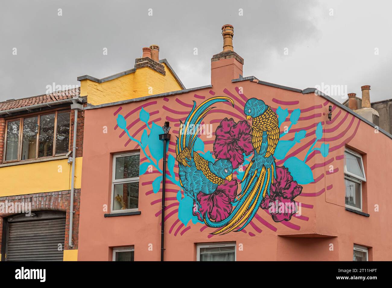 Bristol, Regno Unito - 17 aprile 2023 - casa dipinta di rosa con graffiti blu e bianchi in un angolo Foto Stock