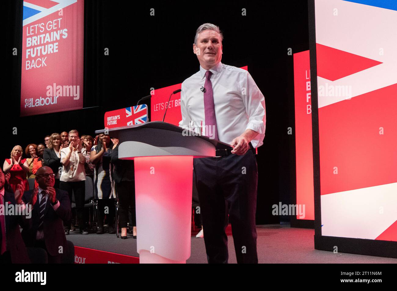 Keir Starmer che era coperto di glitter durante l'inizio del discorso dei leader. Il manifestante fu combattuto a terra e rimosso dalla sicurezza. Sir Keir si spazzolò i capelli si tolse la giacca e proseguì col discorso. La sua camicia, le mani e il pavimento intorno a lui erano ricoperti di glitter e sono rimasti così per tutto il discorso. Sua moglie Victoria Starmer ha applaudito il suo discorso per poi unirsi a lui sul palco alla fine del discorso. Conferenza del lavoro 2023. Immagine: Garyroberts/worldwidefeatures.com Foto Stock