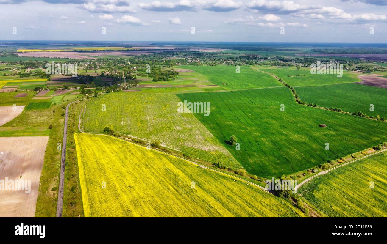 Colorati campi agricoli intorno ad un piccolo villaggio, vista aerea. Foto Stock