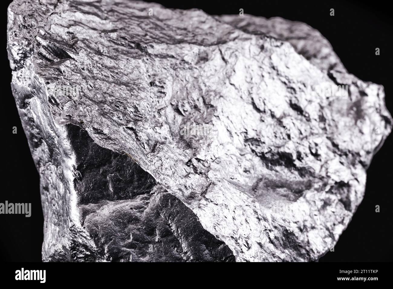 Manganese grezzo. Pietra di manganese isolata su sfondo nero. Estrazione minerale di metalli pesanti. Foto Stock