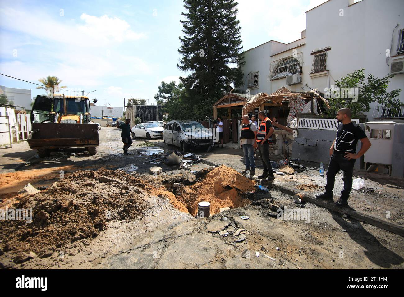 La gente ha visto pulire il caos nelle loro strade intorno alle auto danneggiate dopo il lancio con razzi da parte dei palestinesi in risposta agli attacchi aerei israeliani durante un'operazione a Ramla. I combattimenti tra soldati israeliani e militanti islamici di Hamas continuano nella zona di confine con Gaza. Sconvolto dall'assalto senza precedenti sul suo territorio, un Israele in lutto ha contato oltre 700 morti e ha lanciato un'appassionante raffica di scioperi a Gaza che hanno portato il bilancio delle vittime a 493 secondo i funzionari palestinesi. Foto Stock