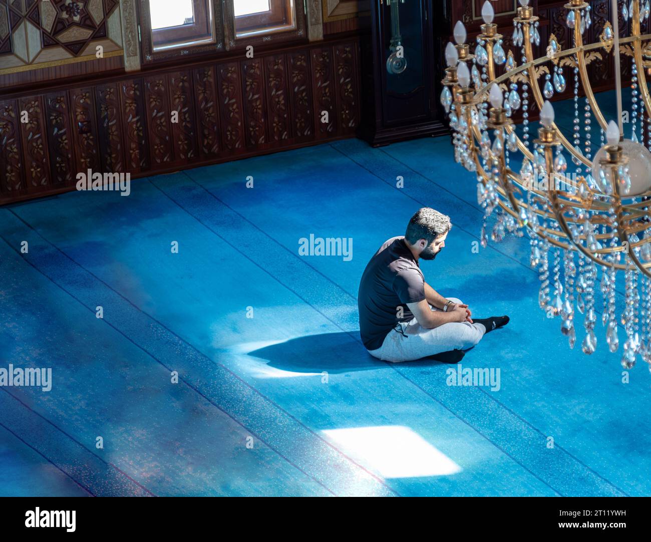 Un uomo seduto a meditare nella moschea con bellissimi tramonti lo toccano Foto Stock