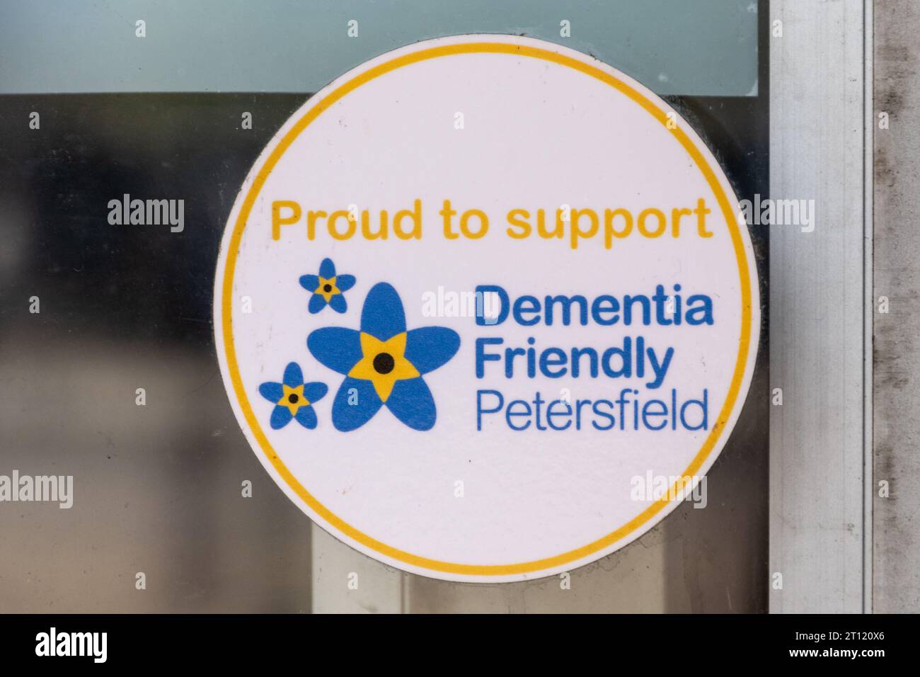 Siamo orgogliosi di supportare l'adesivo Petersfield Friendly per la demenza nella finestra della biblioteca pubblica, Inghilterra, Regno Unito Foto Stock