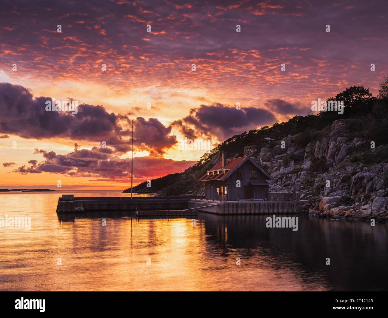 Una tranquilla casa sul lungomare al vivace tramonto in Svezia. Foto Stock