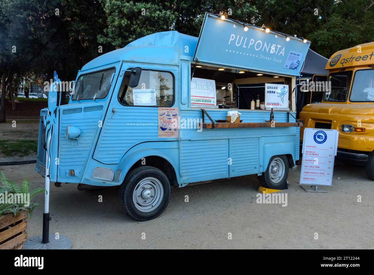 Barcellona, Spagna - 24 ottobre 2023: Furgone retrò preparato per la vendita di fast food. Camion di cibo a un evento nel parco. Foto Stock