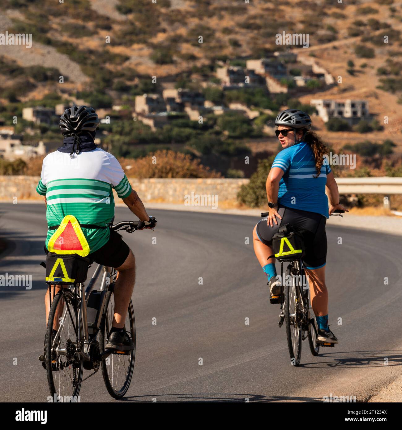 Plaka, Creta, Grecia. 26 settembre 2023. Coppia in bicicletta lungo la strada costiera da Agios Nikolaos, avvicinandosi a Plaka, una città costiera di Creta. Foto Stock