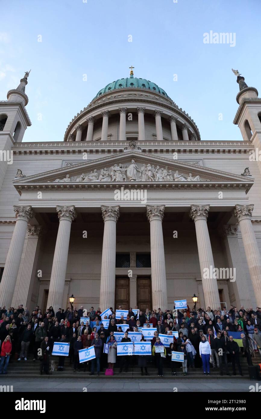 Menschen stehen mit Israelfahnen auf den Stufen der Nikolaikirche während einer Solidaritätskundgebung für Israel, alter Markt, Potsdam, 10. Oktober 2023. Solidaritätskundgebung für Israele a Potsdam *** le persone stanno con le bandiere israeliane sui gradini della chiesa di Nikolaikirche durante un raduno di solidarietà per Israele, Alter Markt, Potsdam, 10 ottobre 2023 raduno di solidarietà per Israele a Potsdam. Credito: Imago/Alamy Live News Foto Stock