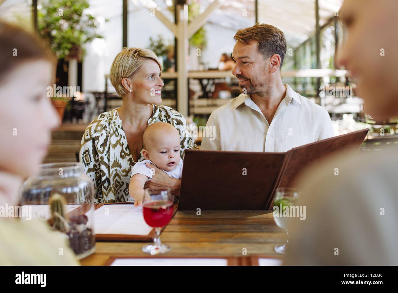 Famiglia con menu per bambini in un ristorante, scelta di cibo e bevande. Foto Stock