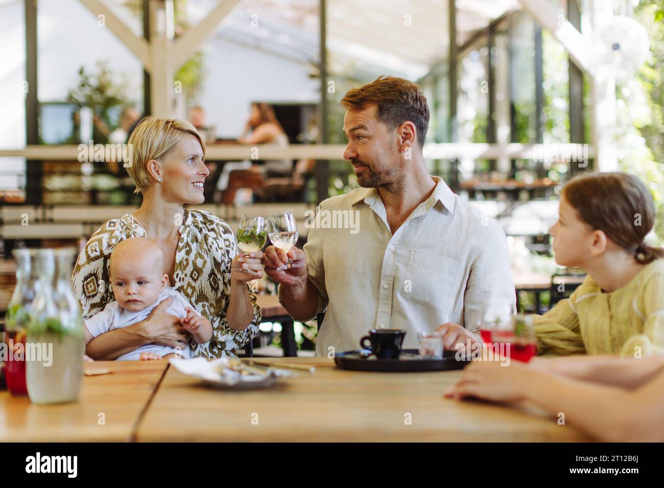 Grande famiglia con bambini e un bambino piccolo a cena in famiglia in un ristorante. Foto Stock