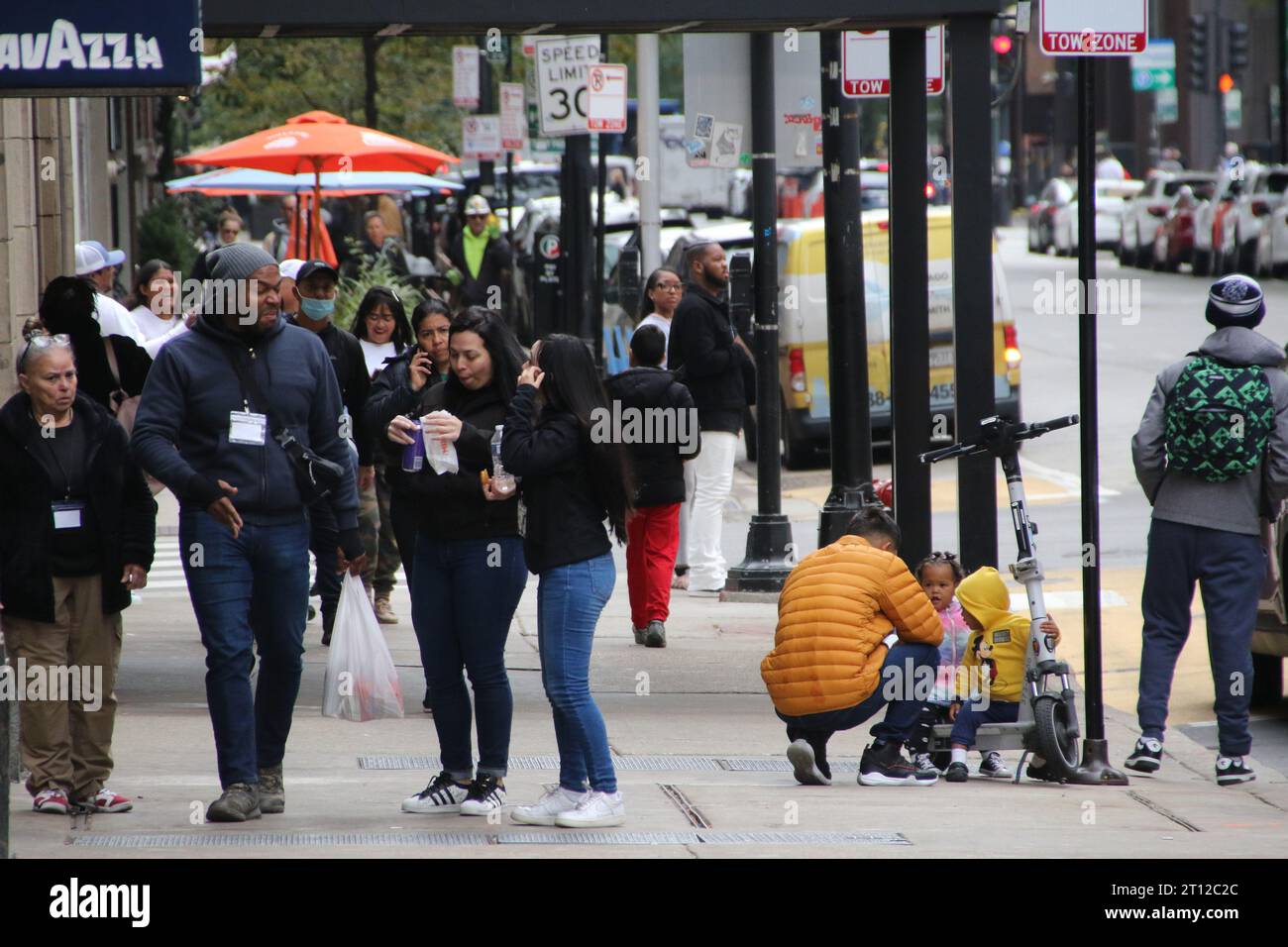 Le famiglie e i bambini migranti si fermano fuori dall'Inn di Chicago, a pochi passi dal Magnificent Mile e dal quartiere finanziario centrale, come visto qui il 10 ottobre 2022. Per oltre un anno, l'Inn of Chicago ha ospitato oltre 1.500 nuovi arrivi, questo ex hotel boutique è circondato da hotel di lusso, ristoranti ed è una delle principali aree turistiche. Due consiglieri del centro chiedono la chiusura di questo rifugio, citando crescenti lamentele da parte dei vicini. (Foto di: Alexandra Buxbaum/Sipa USA) credito: SIPA USA/Alamy Live News Foto Stock