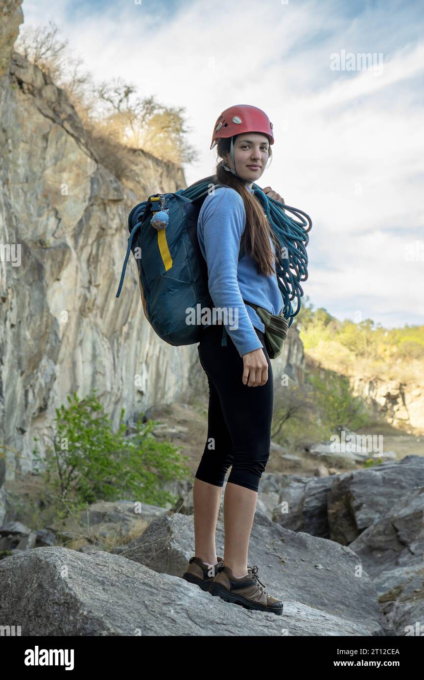Ritratto di una donna alpina che guarda la macchina fotografica ai piedi della montagna rocciosa. Sport estremi all'aperto. Foto Stock