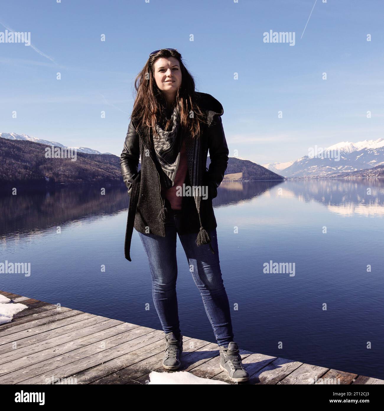 Frau Fröhlich am SEE Berge im Hintergrund Inverno Frühjahr donna sullo sfondo del lago Foto Stock