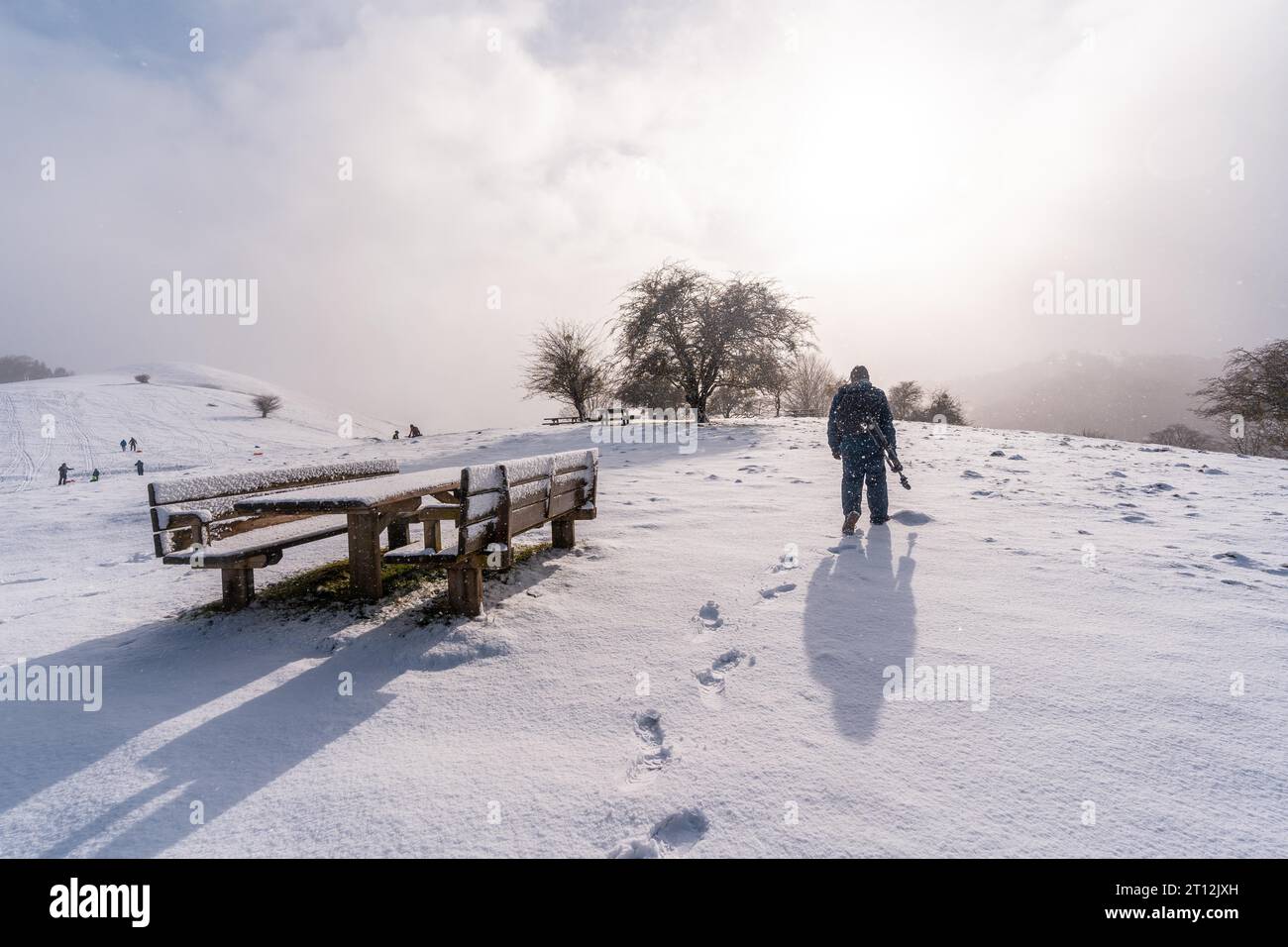 Un giovane fotografo all'alba nell'area picnic accanto al rifugio del Monte Aizkorri a Gipuzkoa. Paesaggio innevato dalle nevicate invernali. Paesi baschi Foto Stock