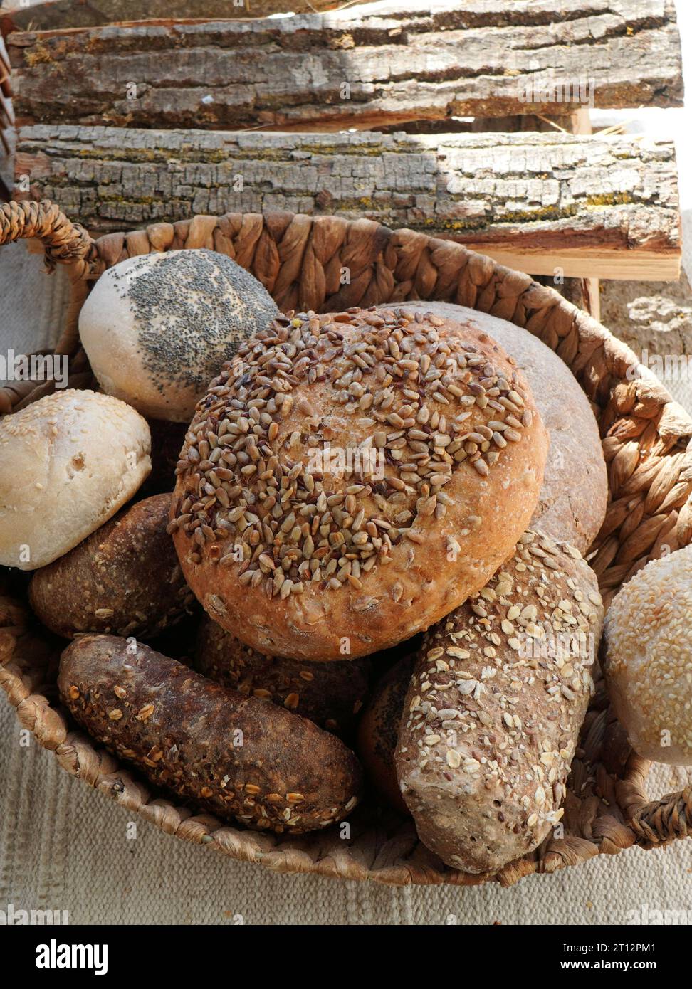 Varietà di pane e panini tradizionali con semi e chicchi interi nel cestino della panetteria Foto Stock