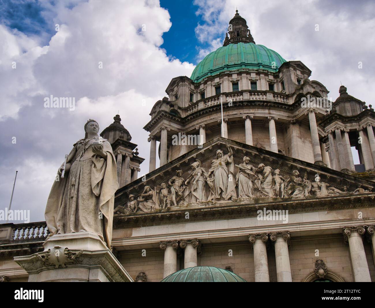 La statua della Regina Vittoria di fronte al Municipio di Belfast. La cupola in rame verde, coronata da lanterna, di 173 piedi (53 m), appare sullo sfondo. Foto Stock
