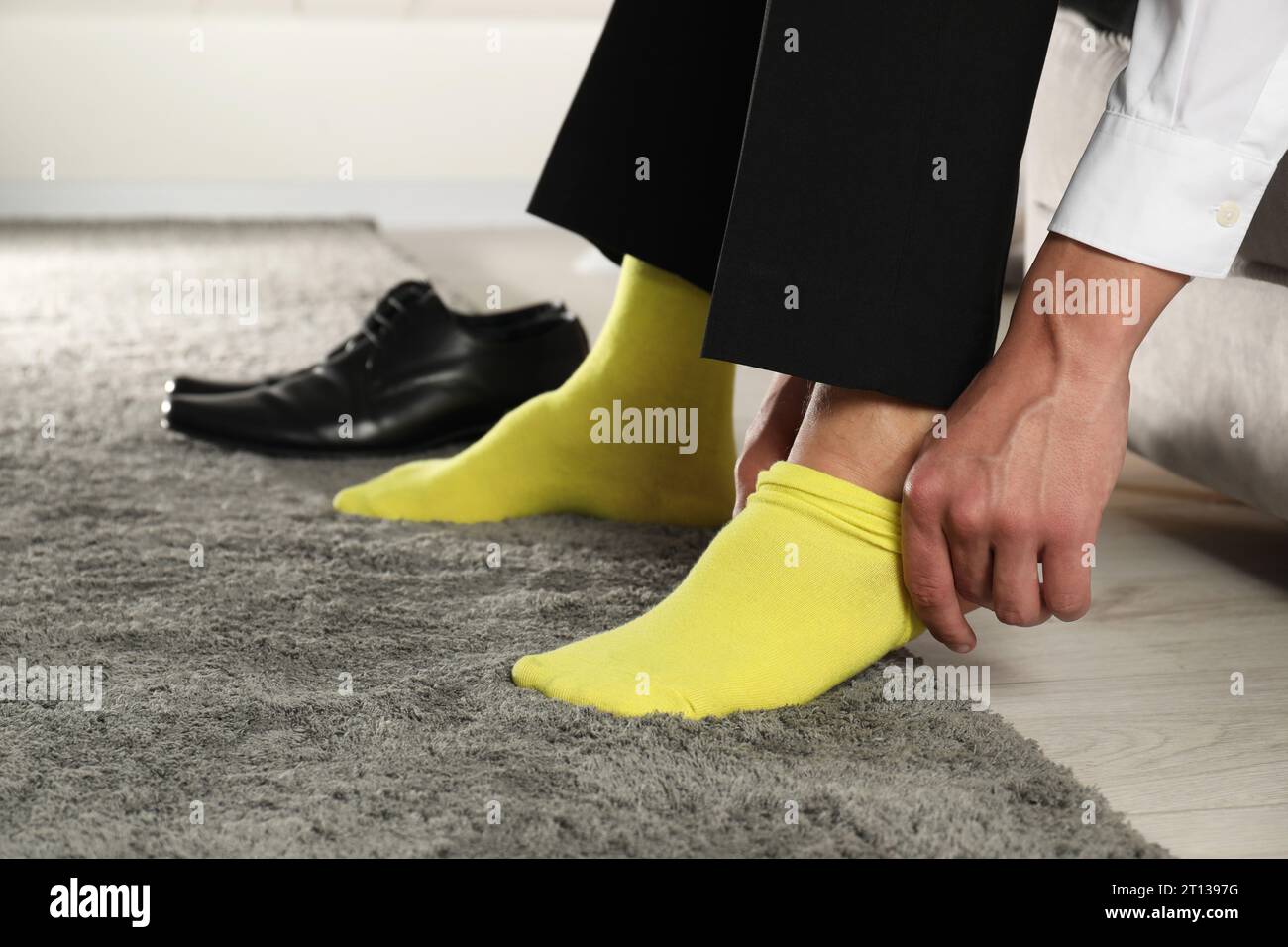 Uomo che indossa calze gialle al chiuso, primo piano Foto Stock