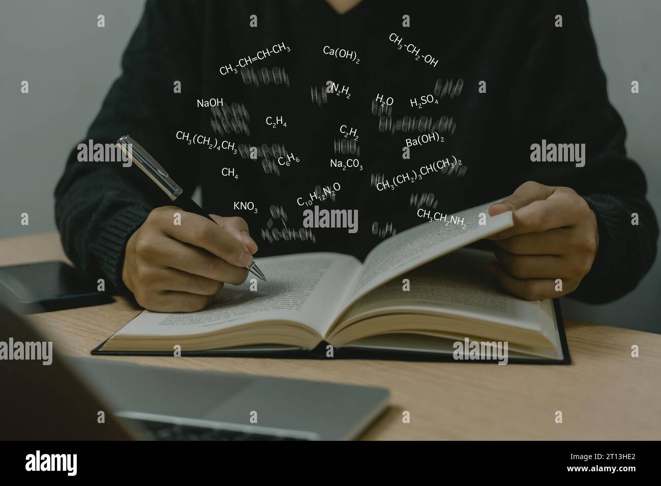 L'uomo che tiene la penna scrive le formule strutturali dei composti chimici icona su uno schermo virtuale su carta. concetto di conoscenza della ricerca scientifica dell'istruzione. Foto Stock