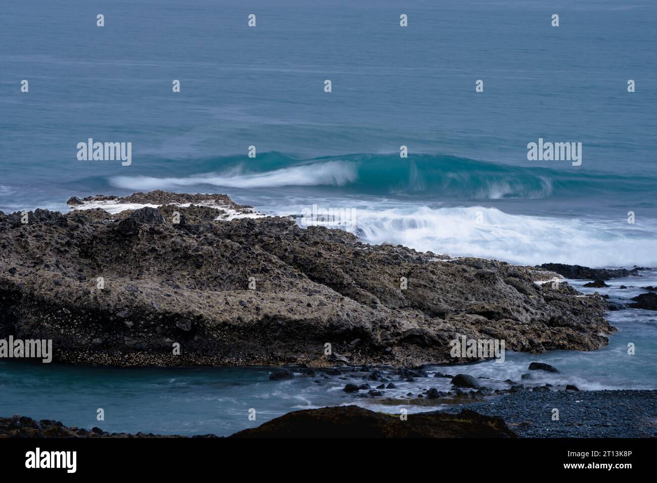 Onde che colpiscono le rocce dell'oceano pacifico Foto Stock