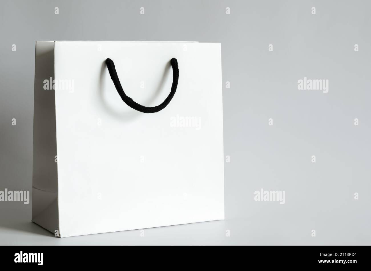 Sacchetto di carta bianca per la spesa su sfondo bianco per il concetto di vendita del Black Friday. Foto Stock
