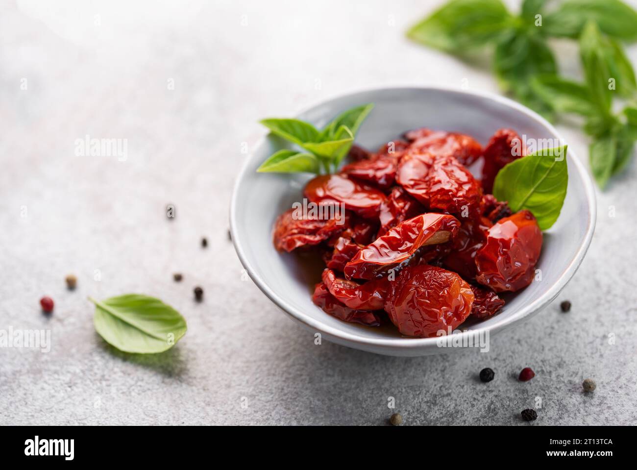 Ciotola con pomodori secchi fatti in casa con erbe fresche e spezie. Foto Stock