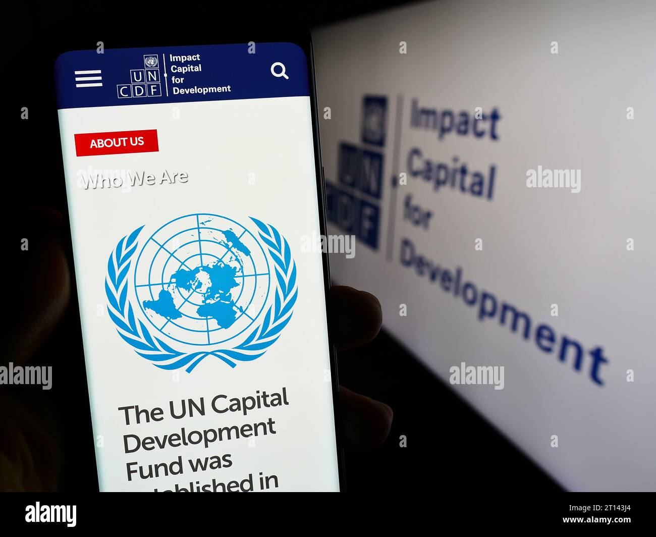 Persona che possiede uno smartphone con la pagina Web del Fondo delle Nazioni Unite per lo sviluppo del capitale (UNCDF) davanti al logo. Concentrarsi sul centro del display del telefono. Foto Stock