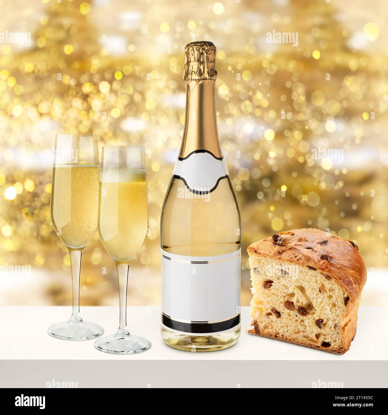 Bottiglia di champagne con bicchieri e fetta di panettone su sfondo dorato e luminoso. Foto Stock