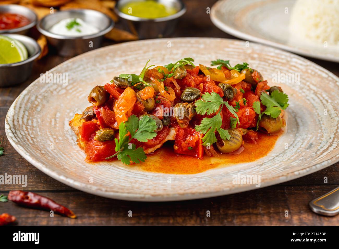 Cibo messicano huachinango a la veracruzana con salse su tavola di legno Foto Stock