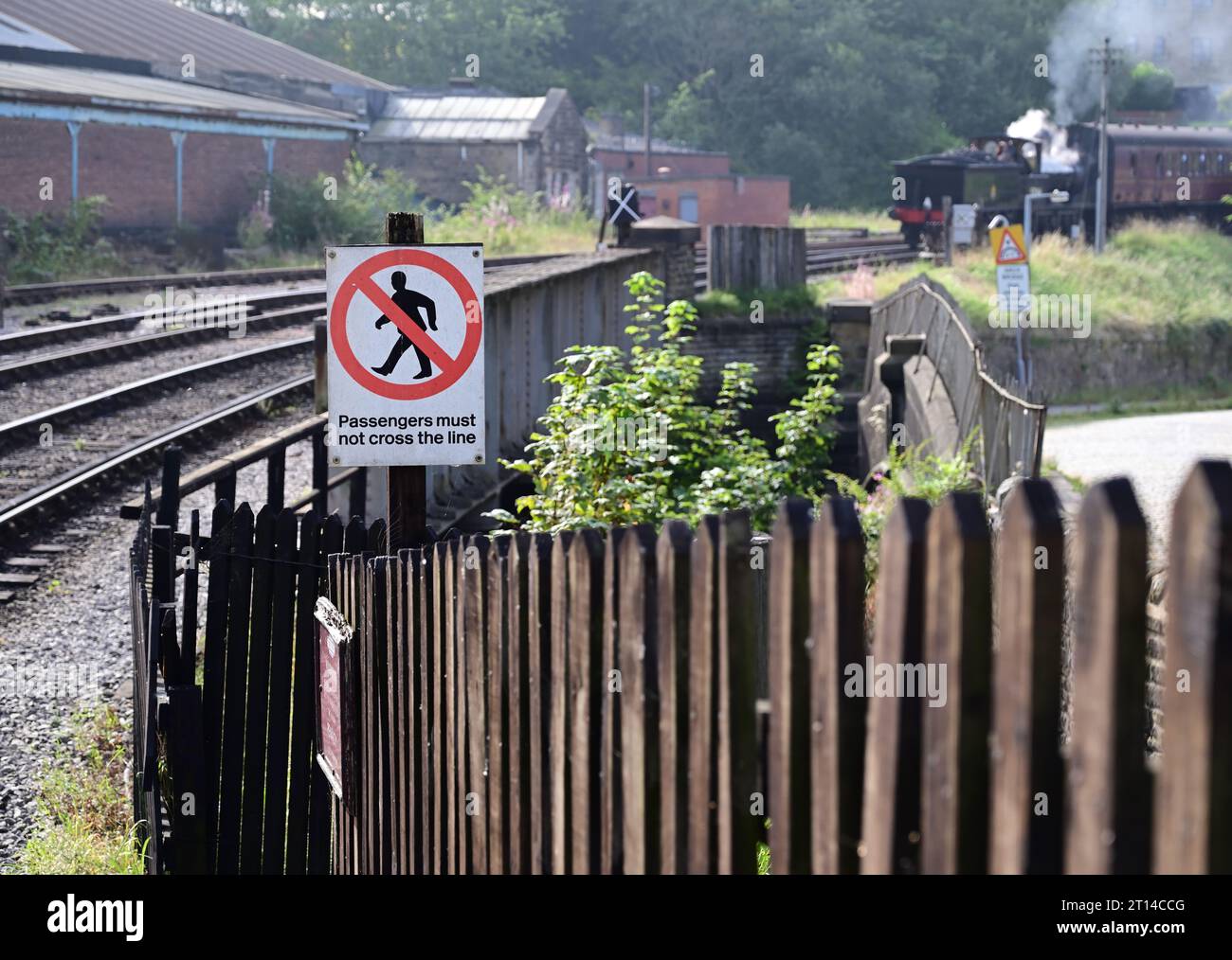 Nota: Si informa i passeggeri di non attraversare la linea alla stazione di Keighley sulla Keighley & Worth Valley Railway, quando si avvicina un treno a vapore. Foto Stock