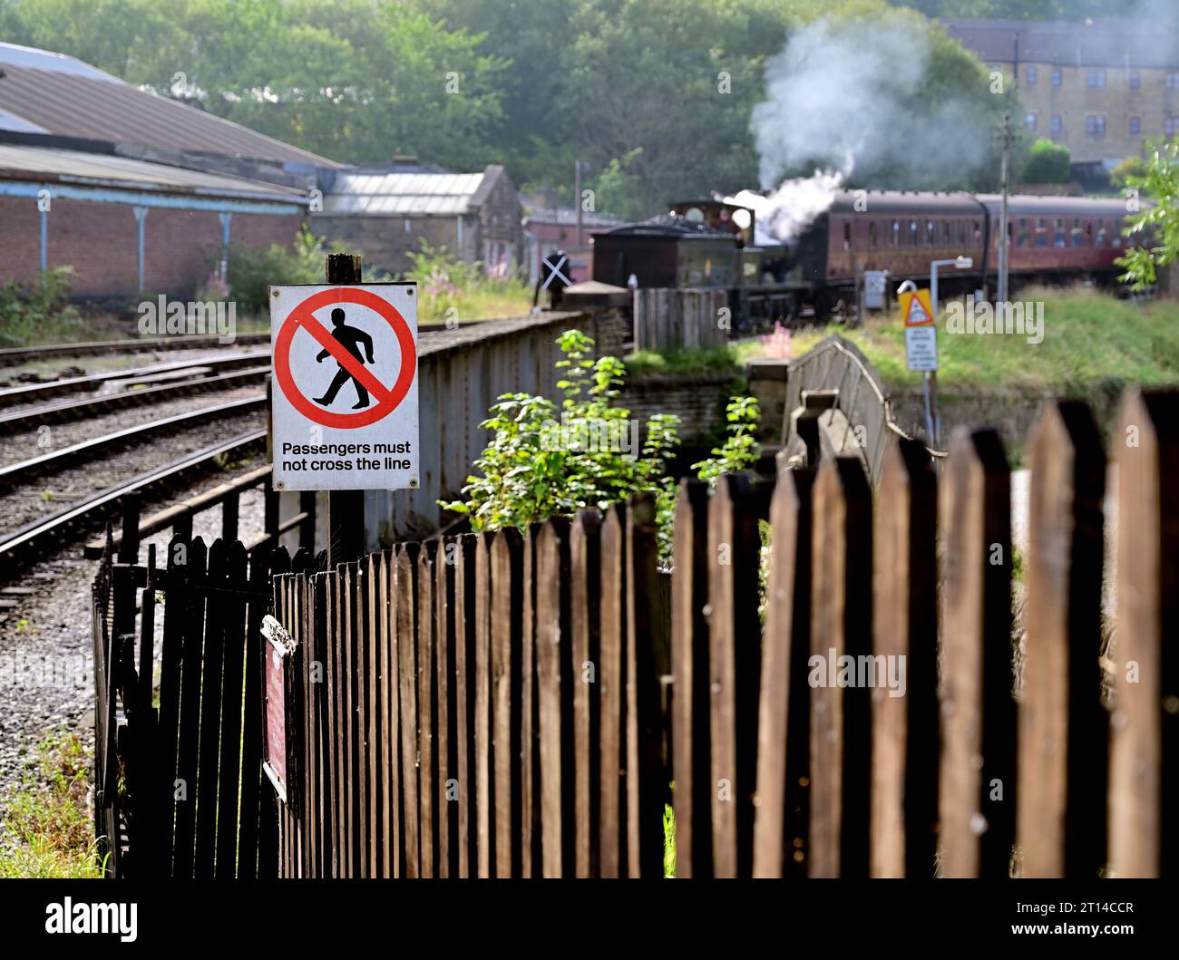Nota: Si informa i passeggeri di non attraversare la linea alla stazione di Keighley sulla Keighley & Worth Valley Railway, quando si avvicina un treno a vapore. Foto Stock