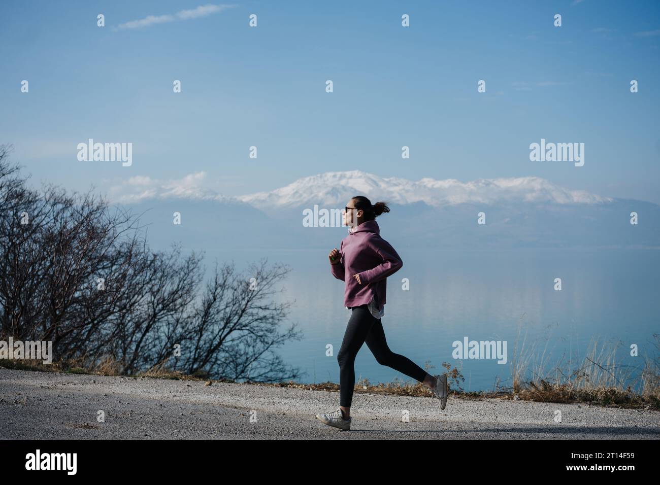 Una ragazza corre in salita, sullo sfondo della natura. Foto Stock