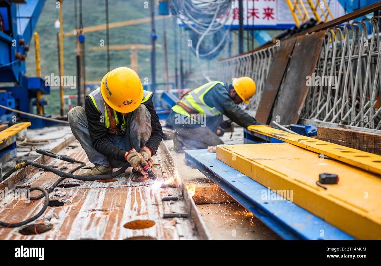 Liupanshui. 9 ottobre 2023. I lavoratori lavorano nel cantiere del grande ponte liuzhi sulla Nayong-Qinglong Expressway nella provincia di Guizhou, nella Cina sud-occidentale, 9 ottobre 2023. La superstrada Nayong-Qinglong, lunga 162 chilometri, consentirà ai veicoli di percorrere 100 chilometri all'ora. Crediti: Tao Liang/Xinhua/Alamy Live News Foto Stock