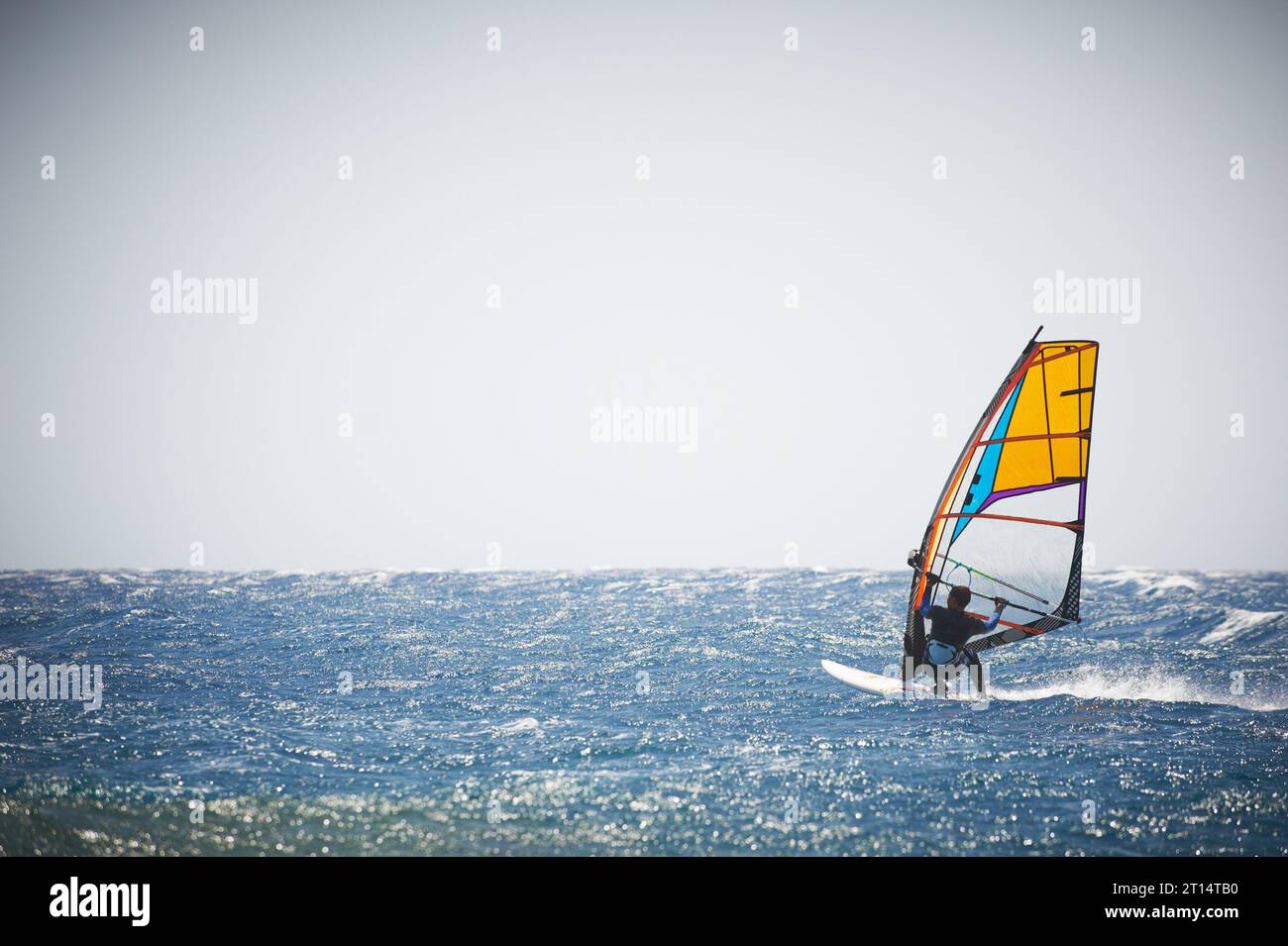 Una vela per windsurf sul mare blu in una giornata ventosa Foto Stock