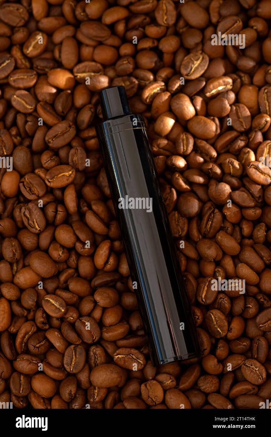 Caffè in grani di fondo e sigaretta elettronica. Concetto di succo di vapore aromatizzato al caffè Foto Stock