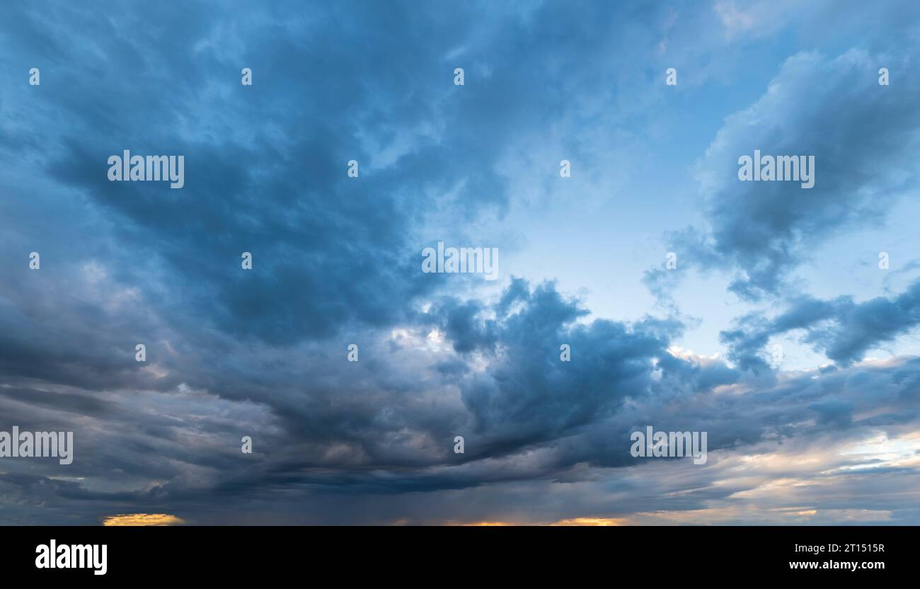 Cielo serale con copertura nuvolosa e basi nuvolose illuminate dal basso dopo il tramonto Foto Stock