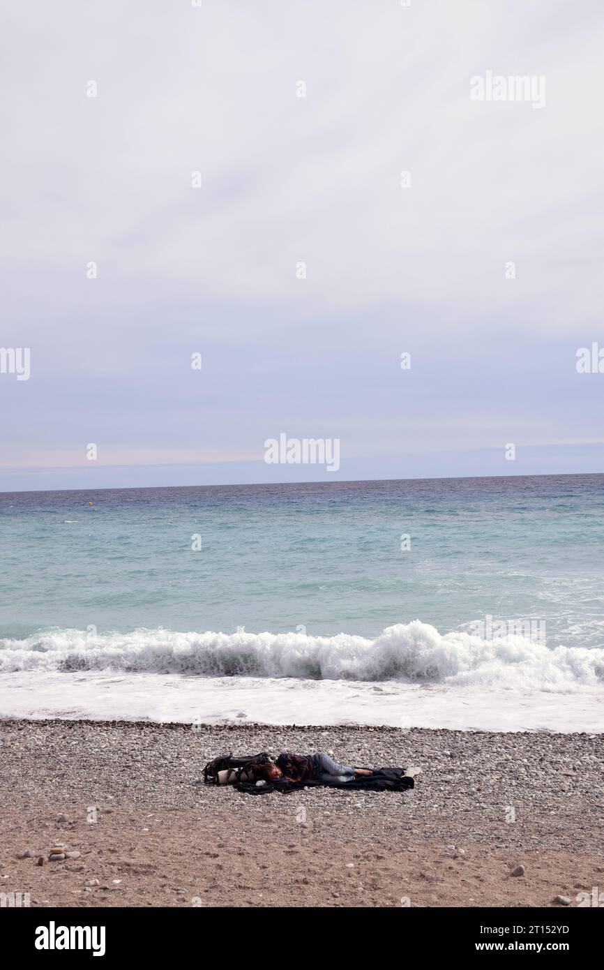 Senzatetto che dorme sulla spiaggia, Mentone, Cote D'Azur, Francia settembre 2023 Foto Stock